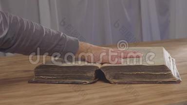 一个人`一本旧<strong>书</strong>上的手掌，圣经上的<strong>誓言</strong>。 上面的俯视图